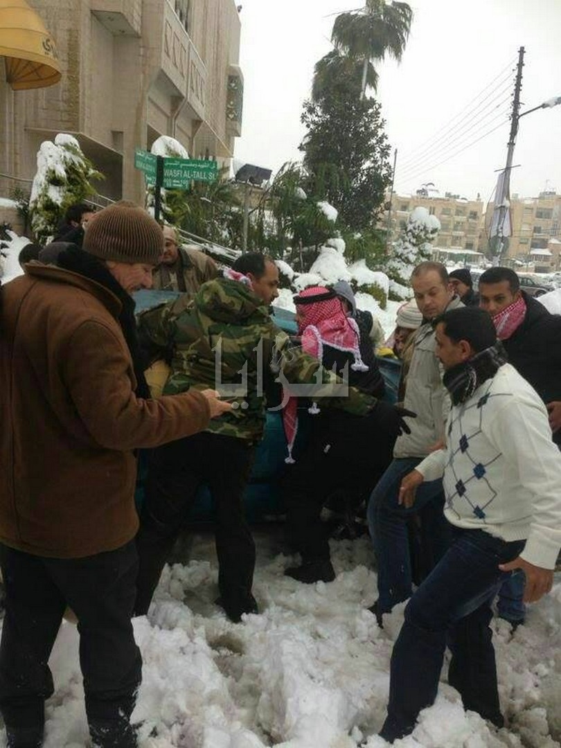 بالصور..الملك يدفع سيارات عالقة بشارع الجاردنز ويساعد المواطنين Image