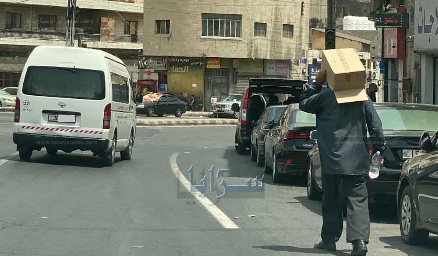 شاهد - رجل يرتدي "كرتونة" برأسه نتيجة الحر الشديد في عمان 