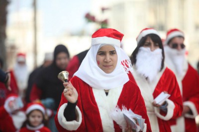 بالصور  ..  "بابا نويل" يرسم البسمة على وجوه الأطفال والمواطنين برام الله